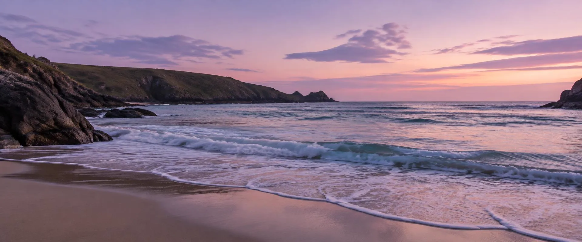 Gentle waves on a Cornish cove at dusk